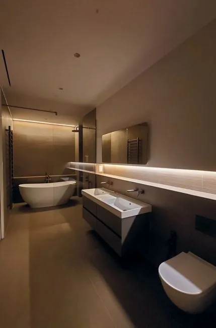 Bathroom with a freestanding bath, wall-hung vanity and concealed lighting