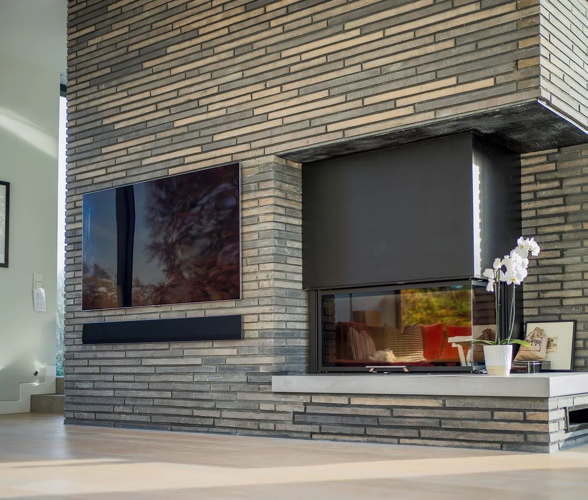 Living room fireplace in long, slim grey brick with an inset fire